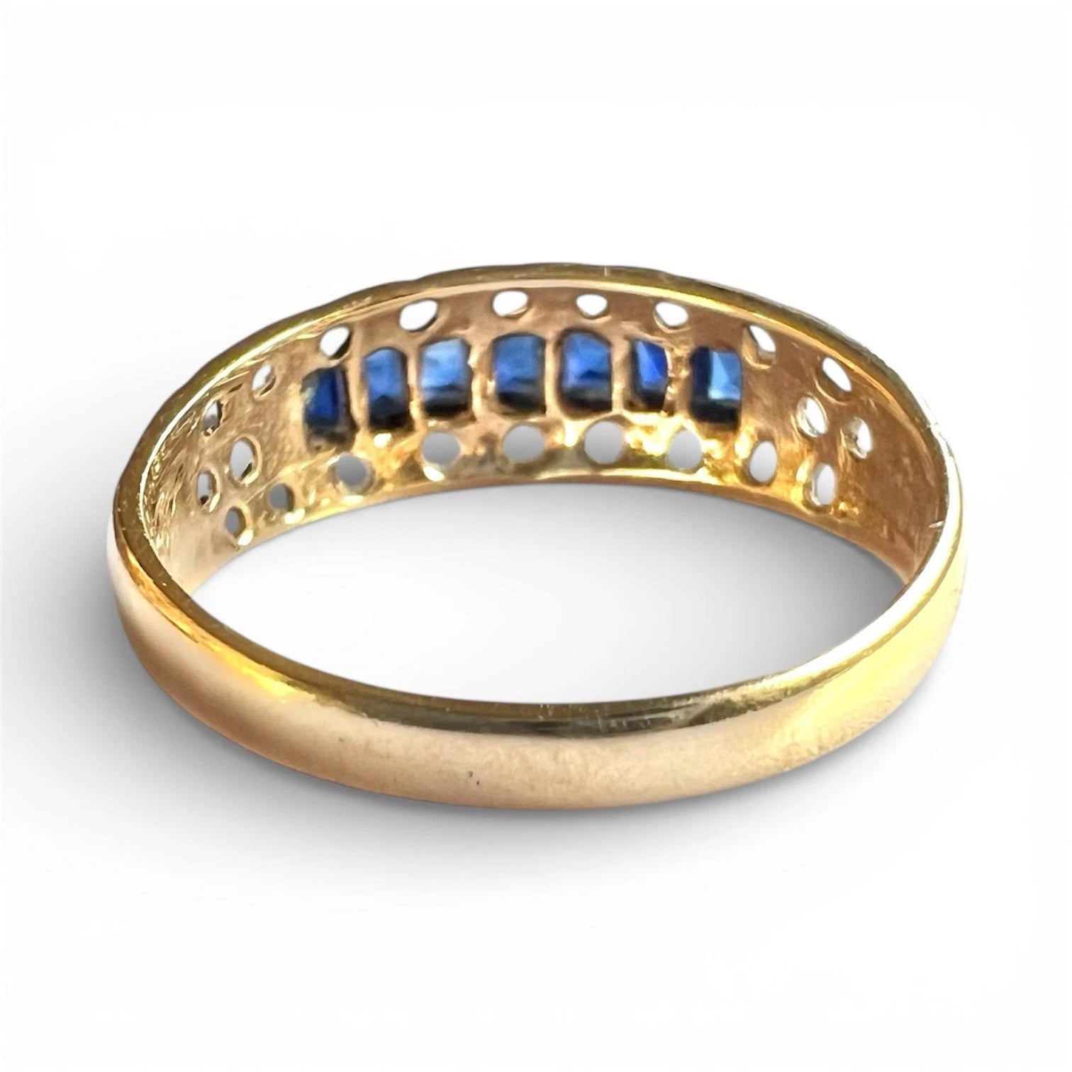 Rear view gold ring with blue sapphire gemstones on a white background