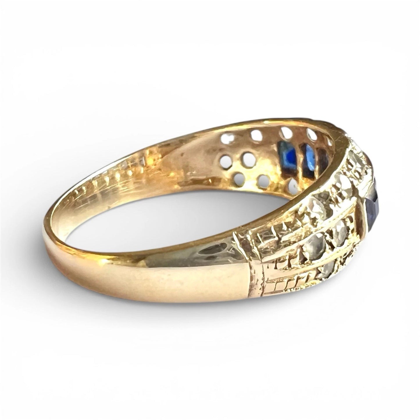Gold ring with intricate design on a white background