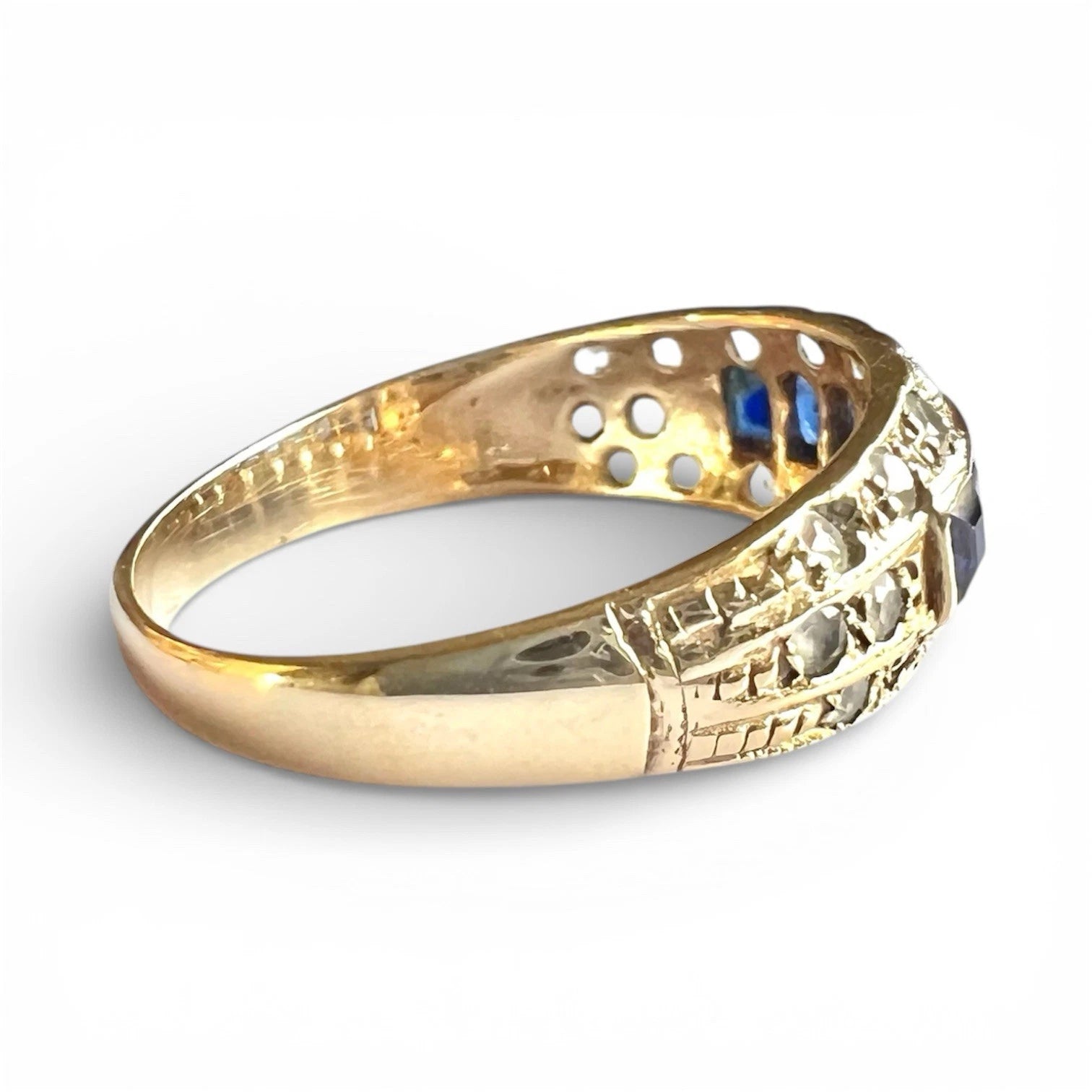 Gold ring with intricate design on a white background