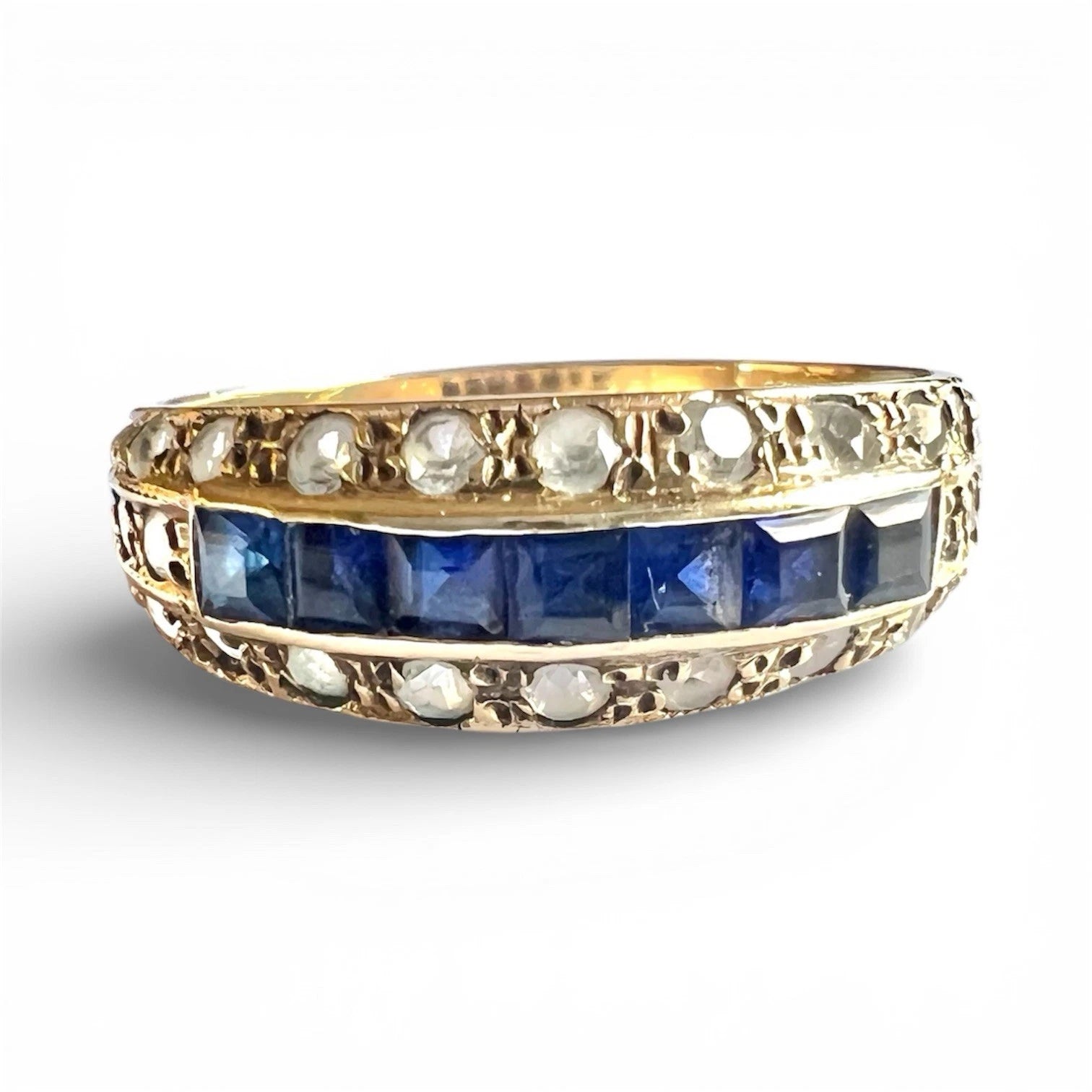 Gold ring with blue square cut sapphire gemstones and cubic zirconia on a white background