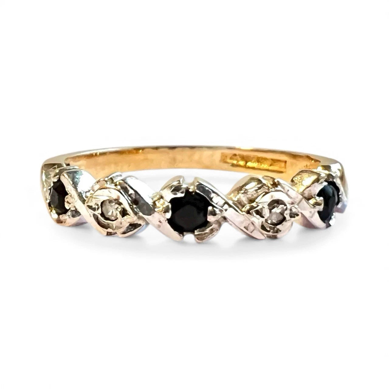 Gold ring with alternating sapphire and diamond on a white background. Close up front view. 