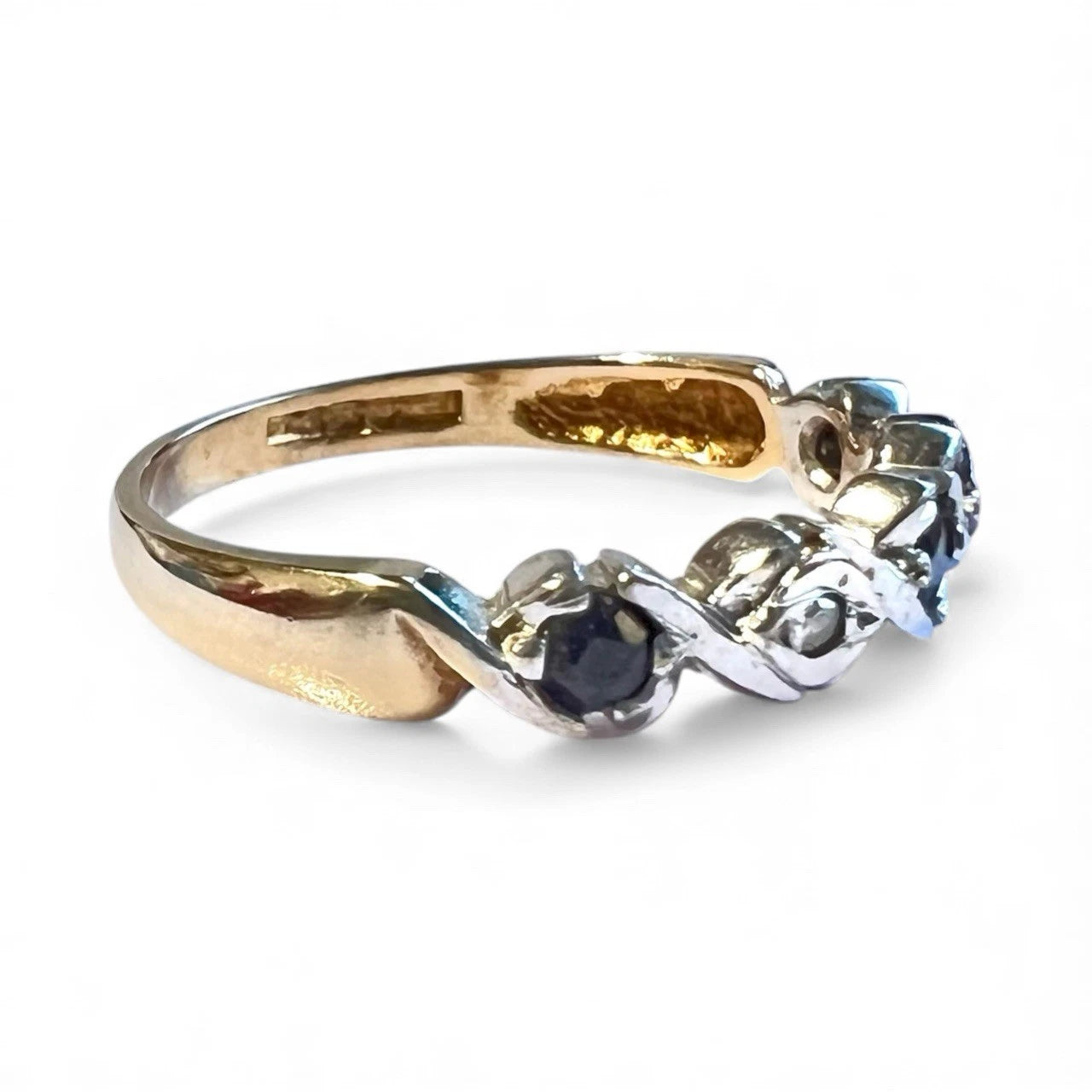 Gold ring with sapphire and diamond gemstone on a white background. Close up side view 
