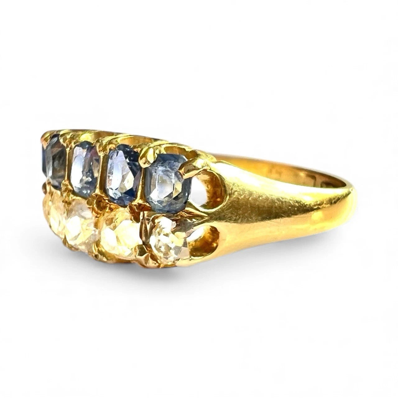 Antique gold ring with embedded sapphire and diamond stones on a white background