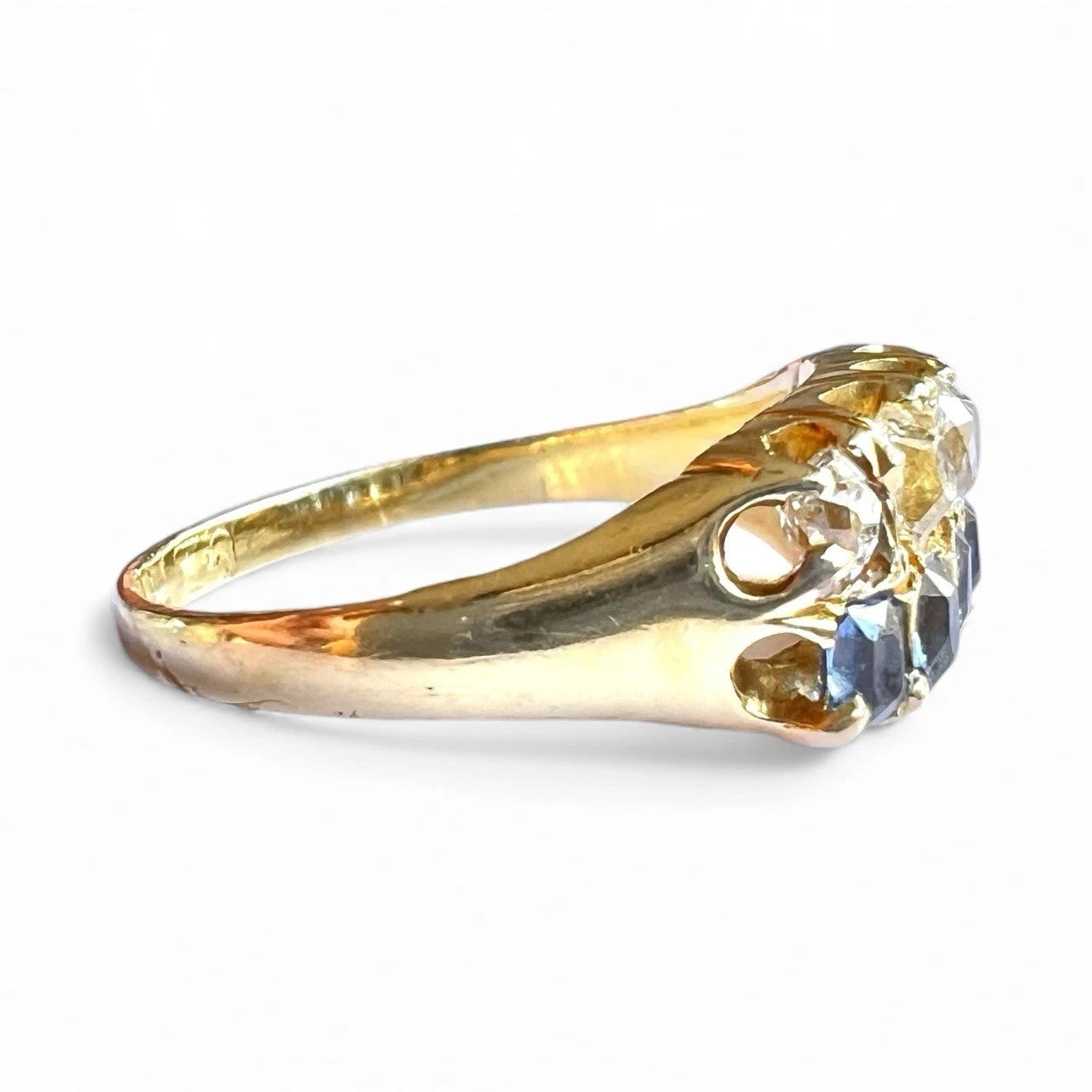 Gold ring with a sapphires and diamond on a white background