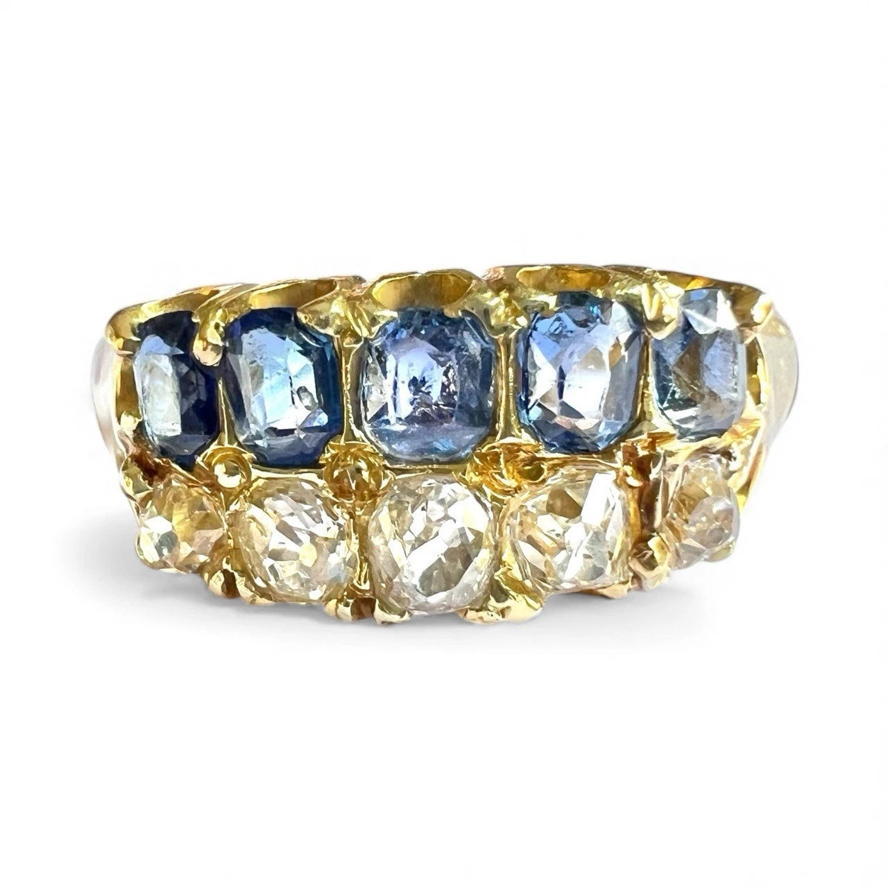 Victorian gold ring with blue sapphire and diamond gemstones on a white background