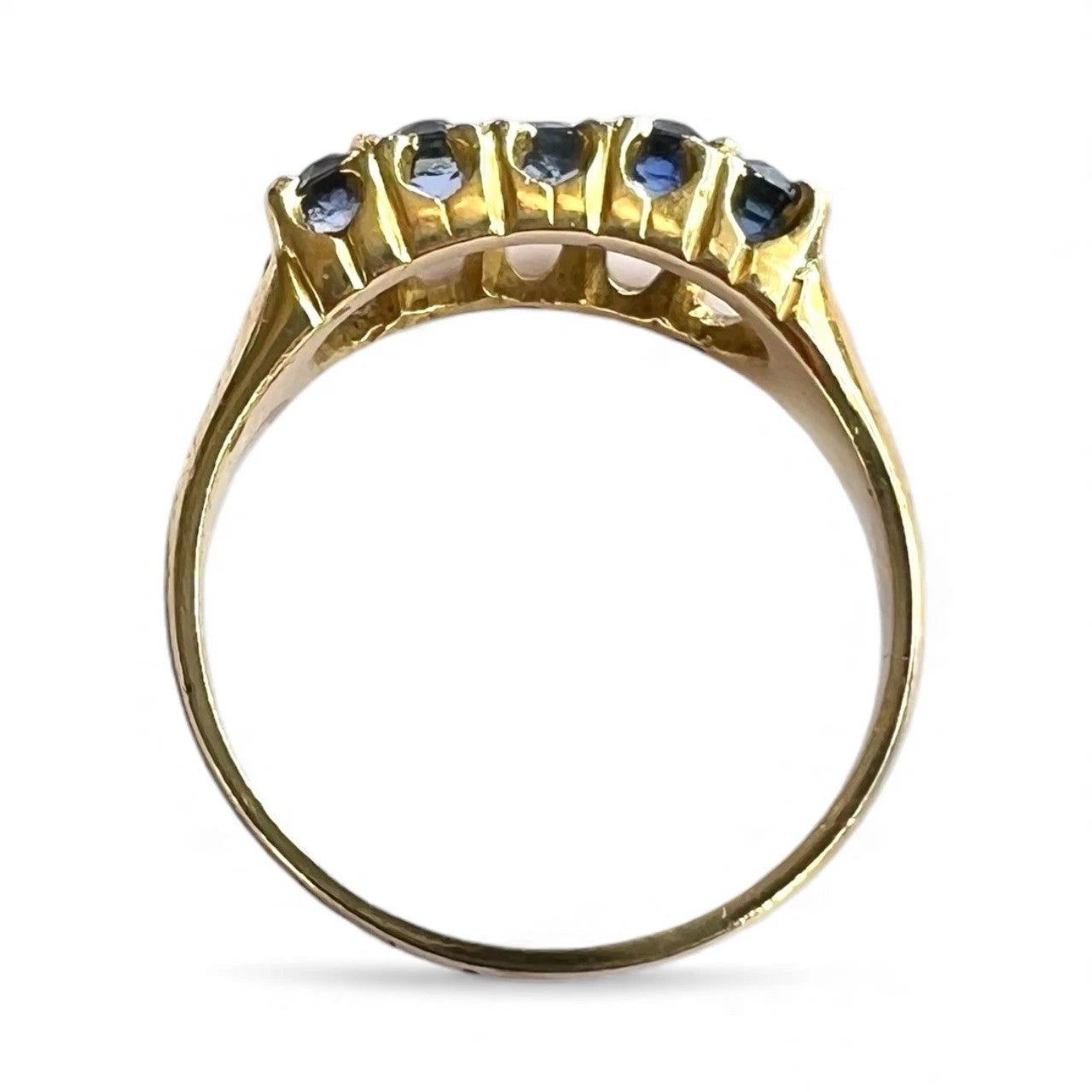 Gold ring with blue gemstones on a white background