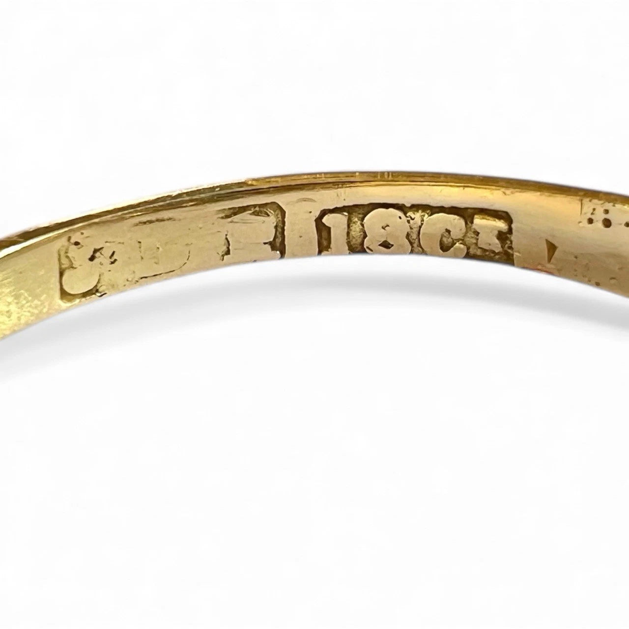 Gold ring with '18K' marking on a white background