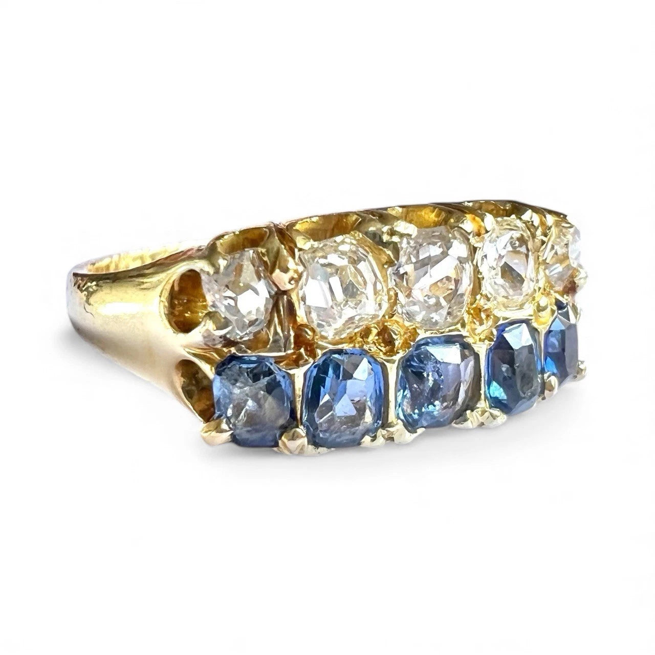 Gold ring with diamonds and blue sapphires on a white background
