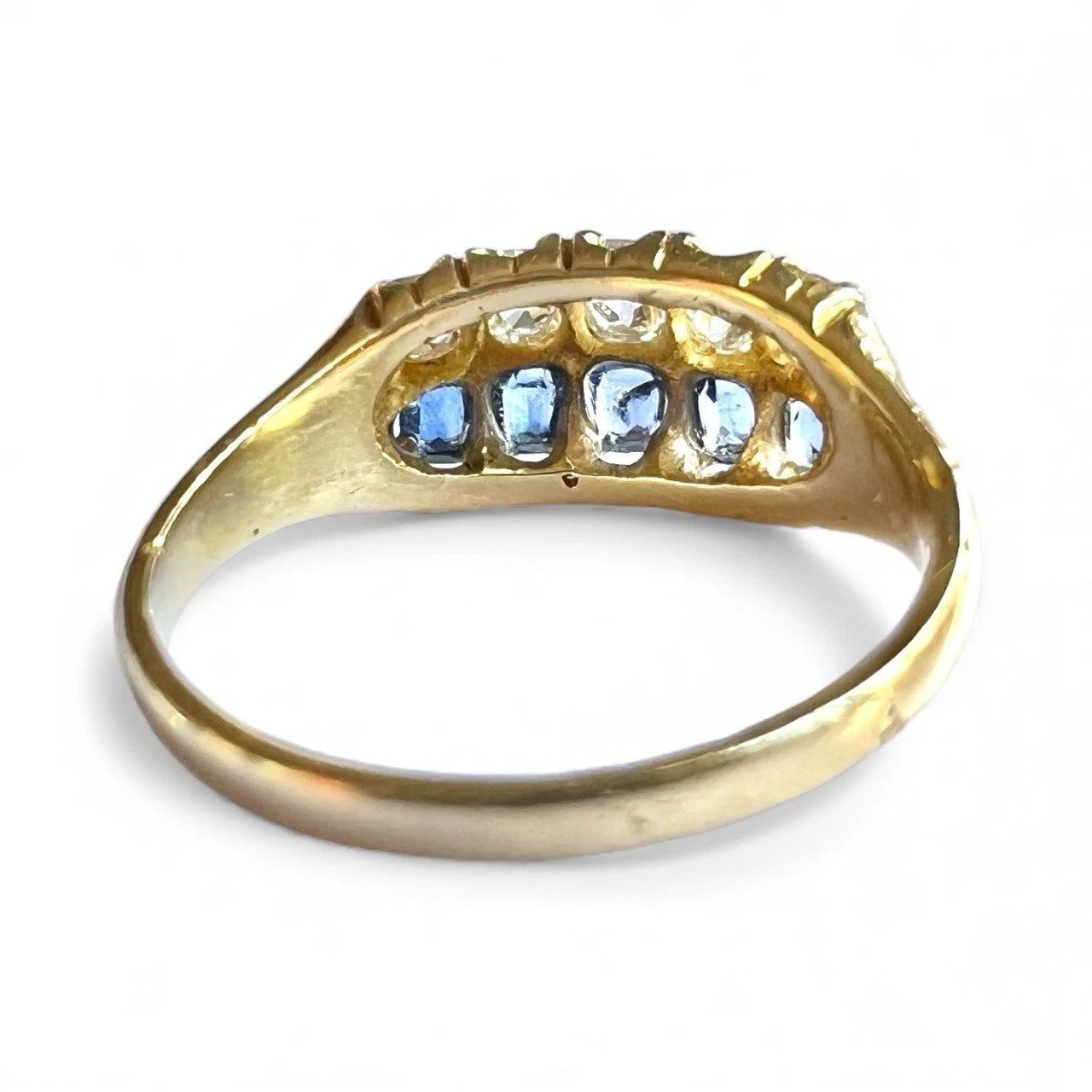 Victorian gold ring with blue sapphire diamond gemstones on a white background