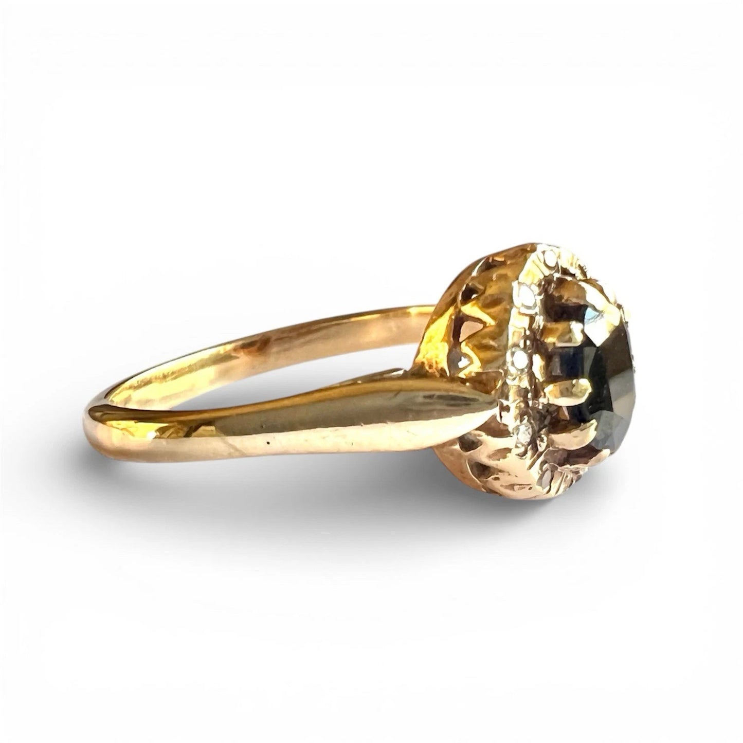 Side view gold ring with a large sapphire gemstone on a white background