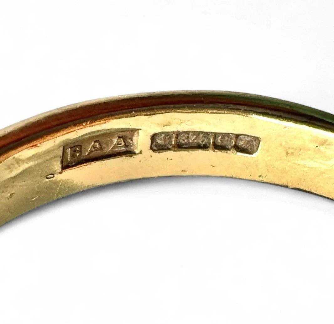 Gold ring with visible hallmark on a white background