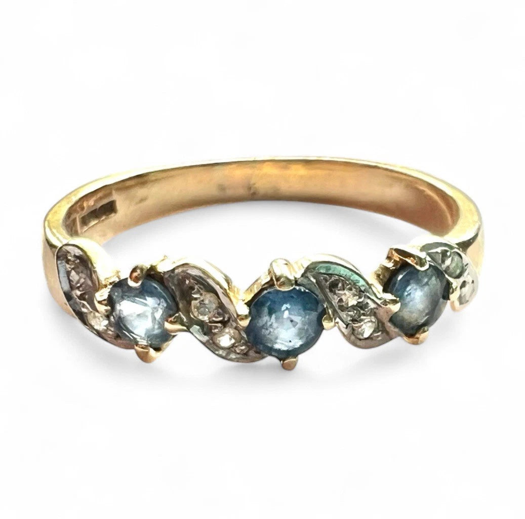 Gold ring with blue sapphire gemstones on a white background