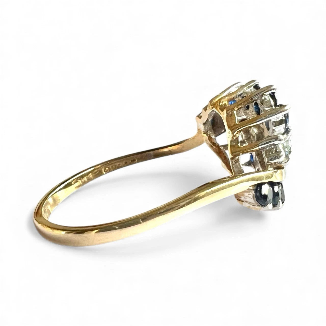Gold ring with sapphire diamonds  on a white background close up side view of gold band 