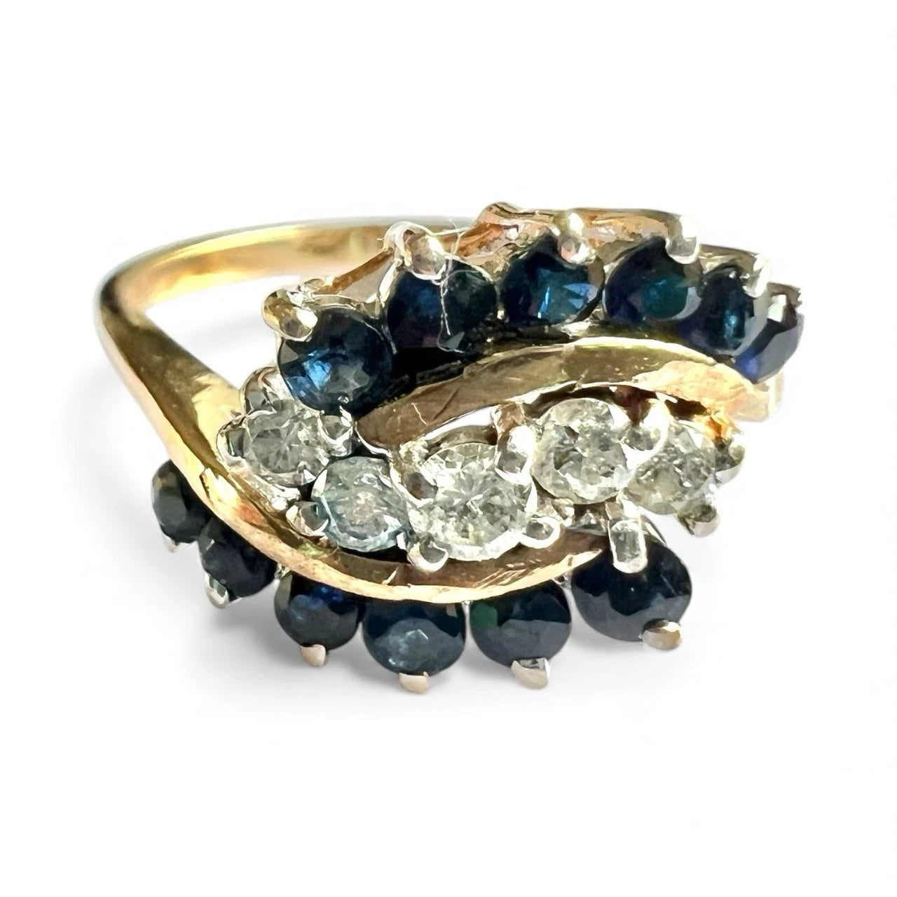 Gold ring with blue sapphire and diamonds on a white background close up front view 