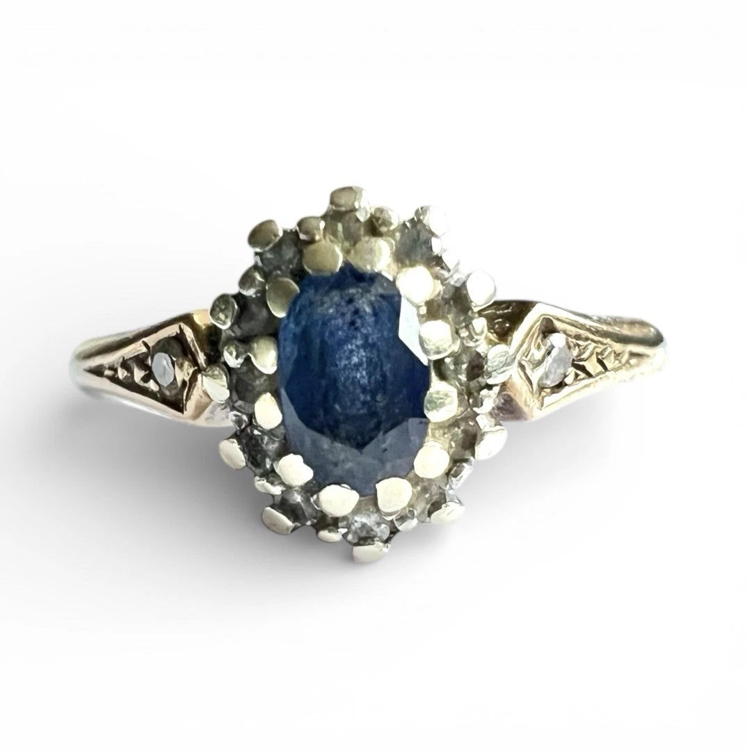 Ring with a blue sapphire gemstone and diamond stones halo on a white background