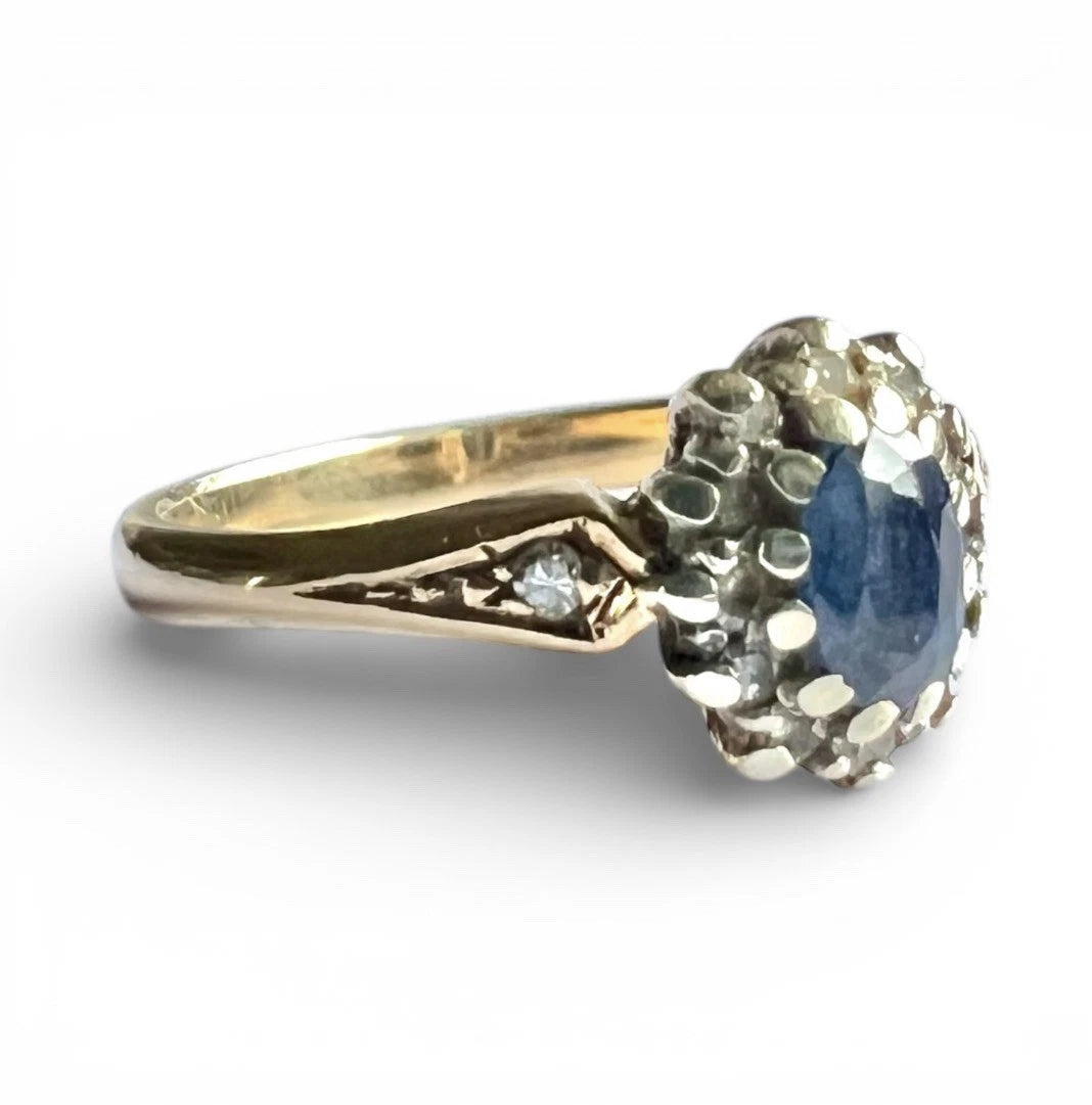 Gold ring with a blue sapphire gemstone on a white background