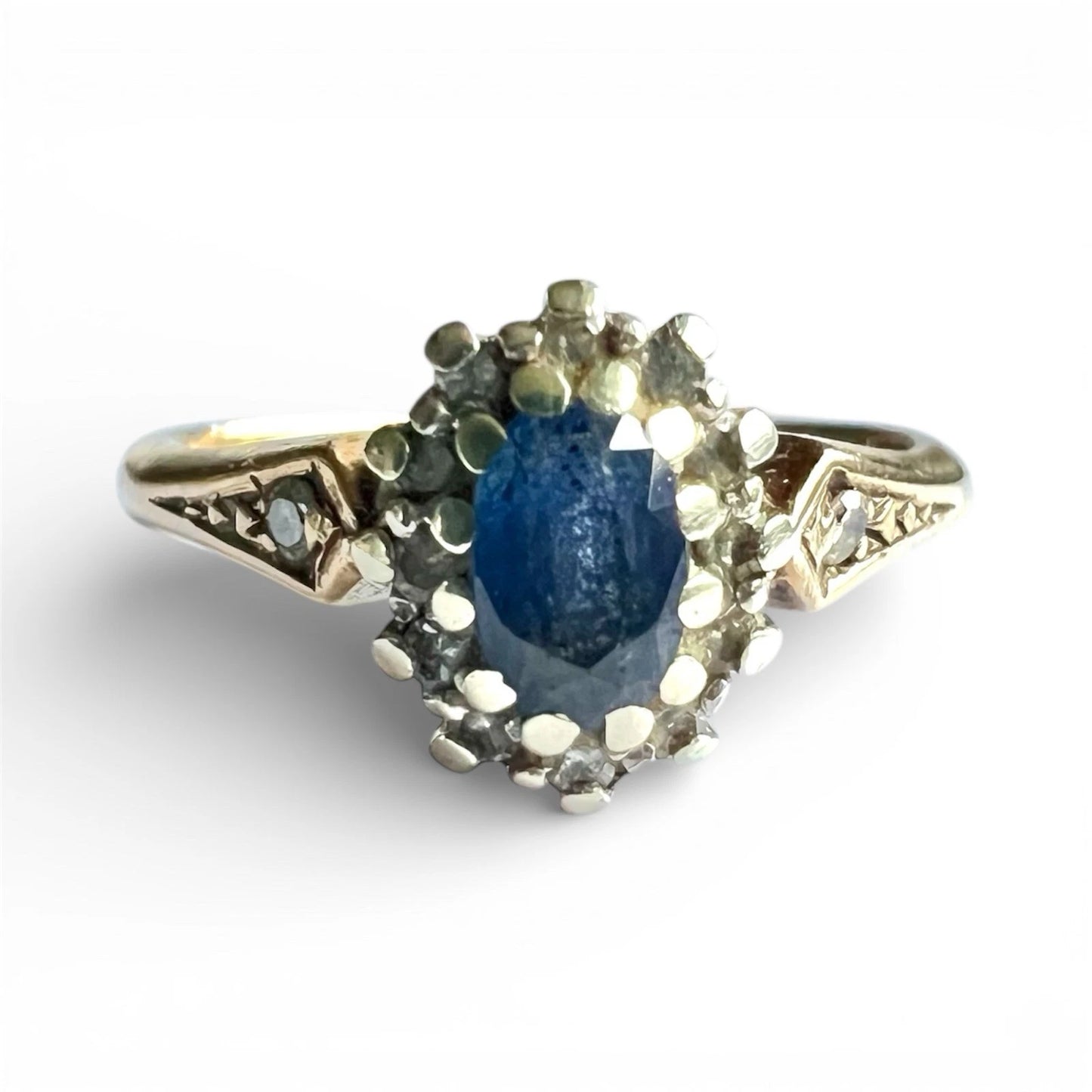 Gold ring with a oval cut blue sapphire gemstone on a white background