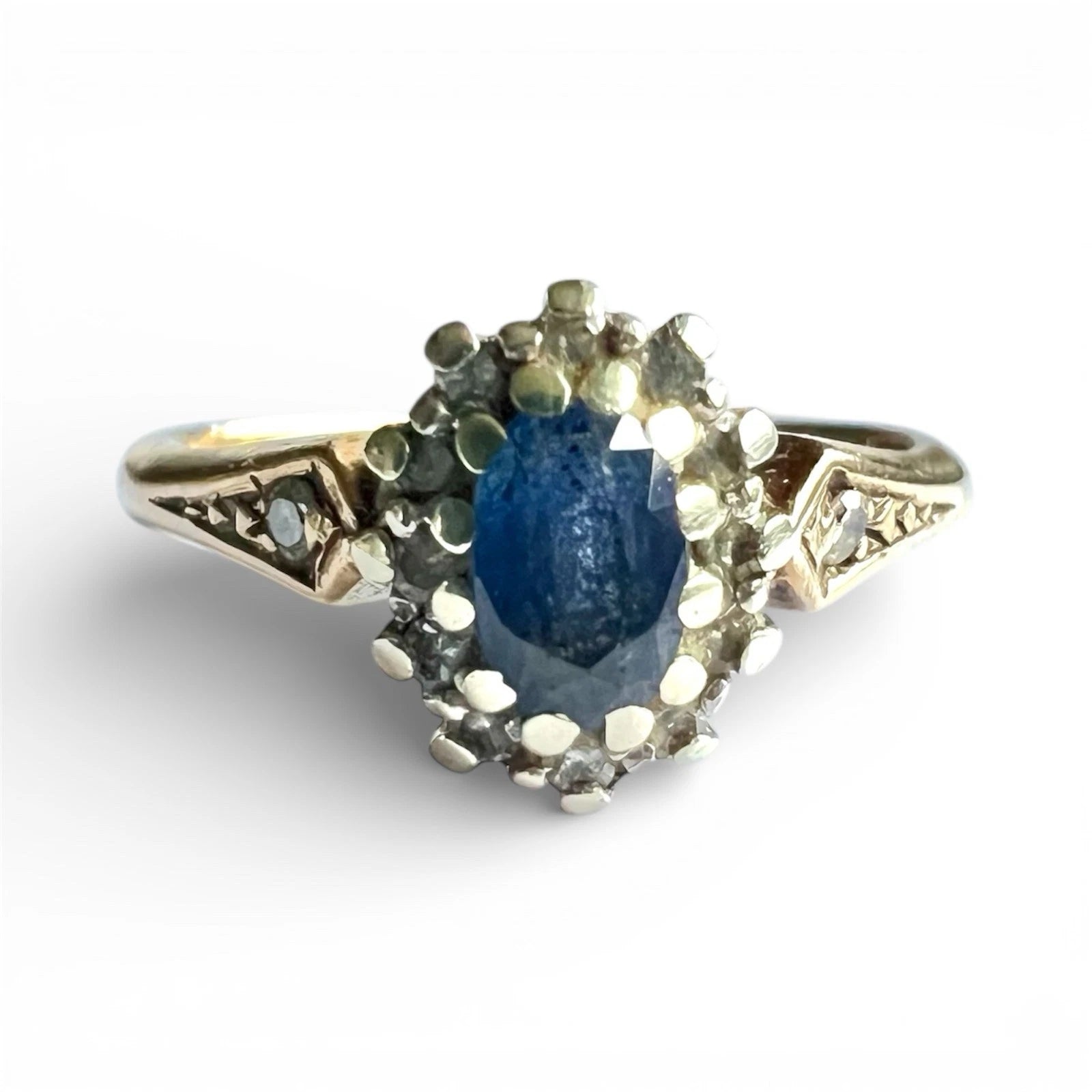 Gold ring with a oval cut blue sapphire gemstone on a white background