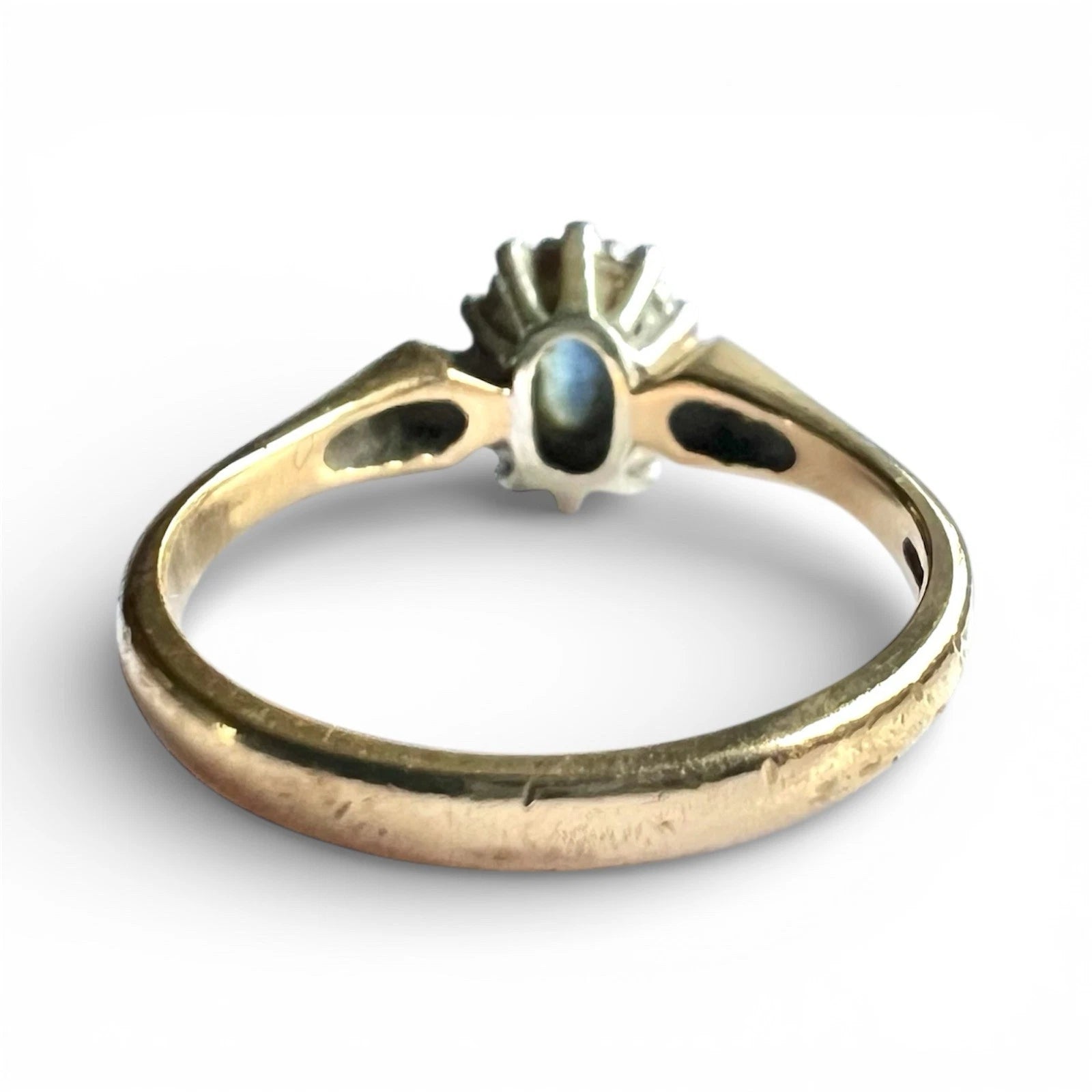 Gold ring with a central gemstone on a white background