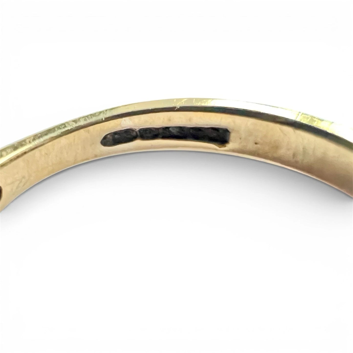 Gold ring with indistinct hallmarks on a white background 