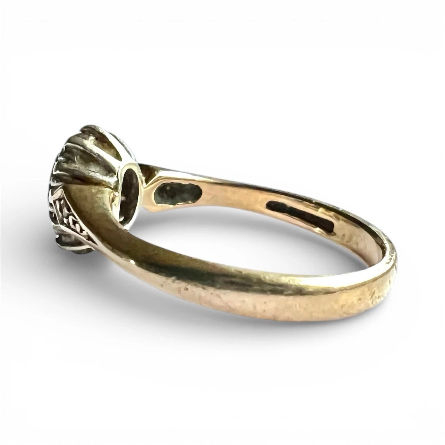 Gold ring with intricate design on a white background