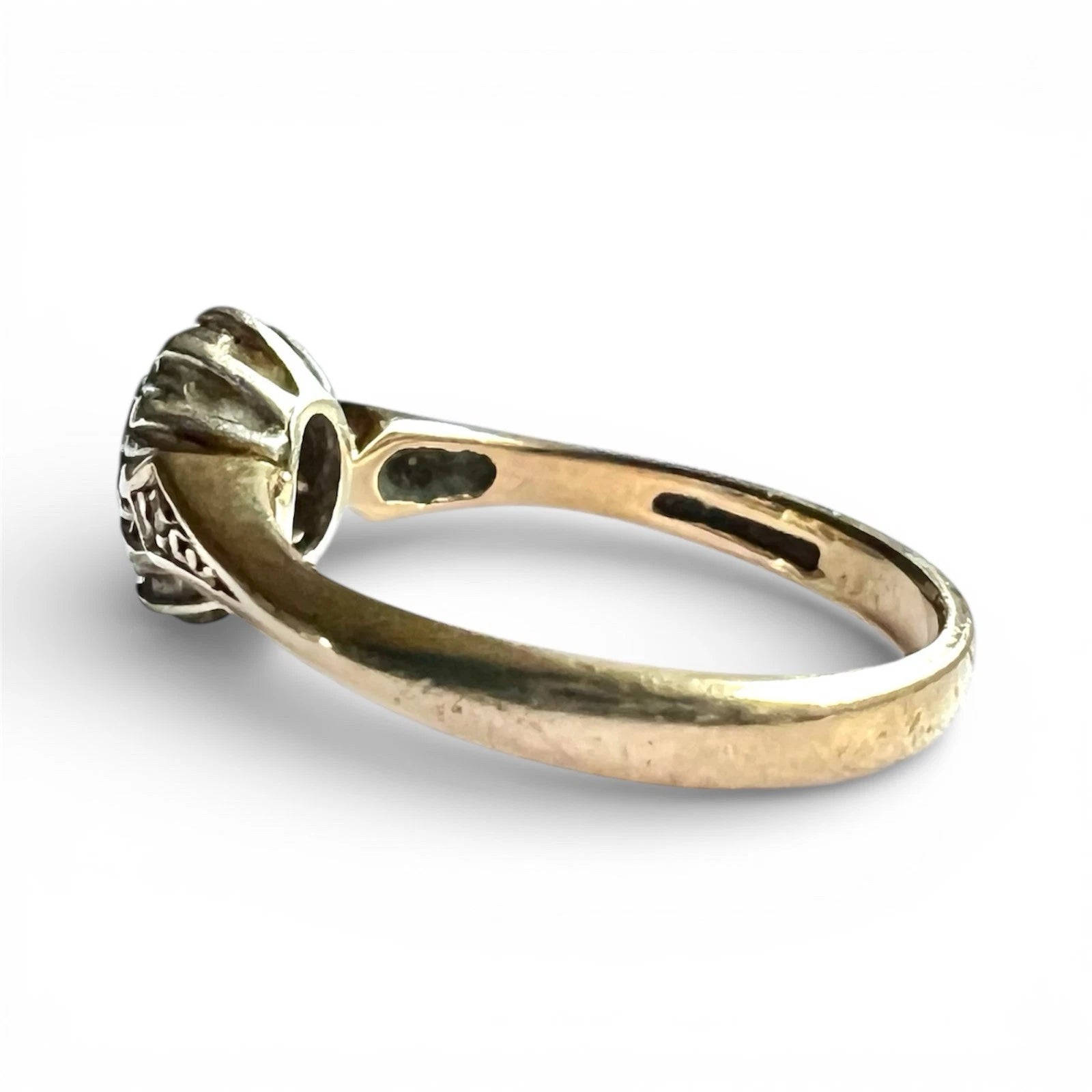 Gold ring with intricate design on a white background