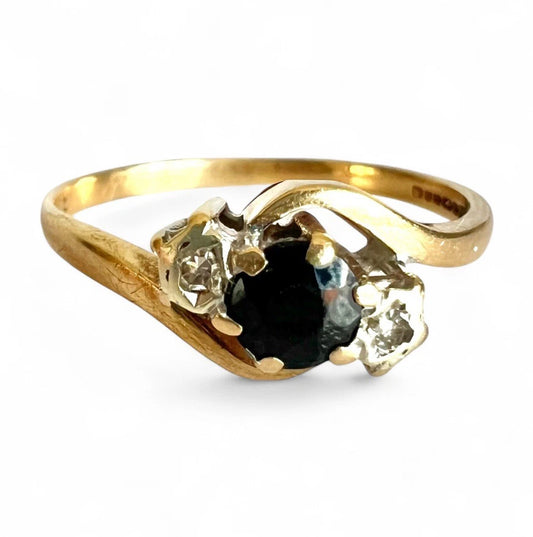 Gold ring with a sapphire and diamonds on a white background