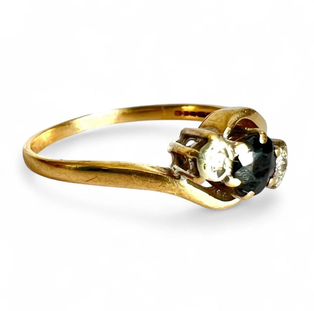 Gold ring with a sapphire and diamond on a white background