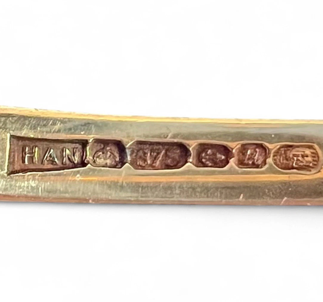 Gold ring with engraved hallmark on a white background