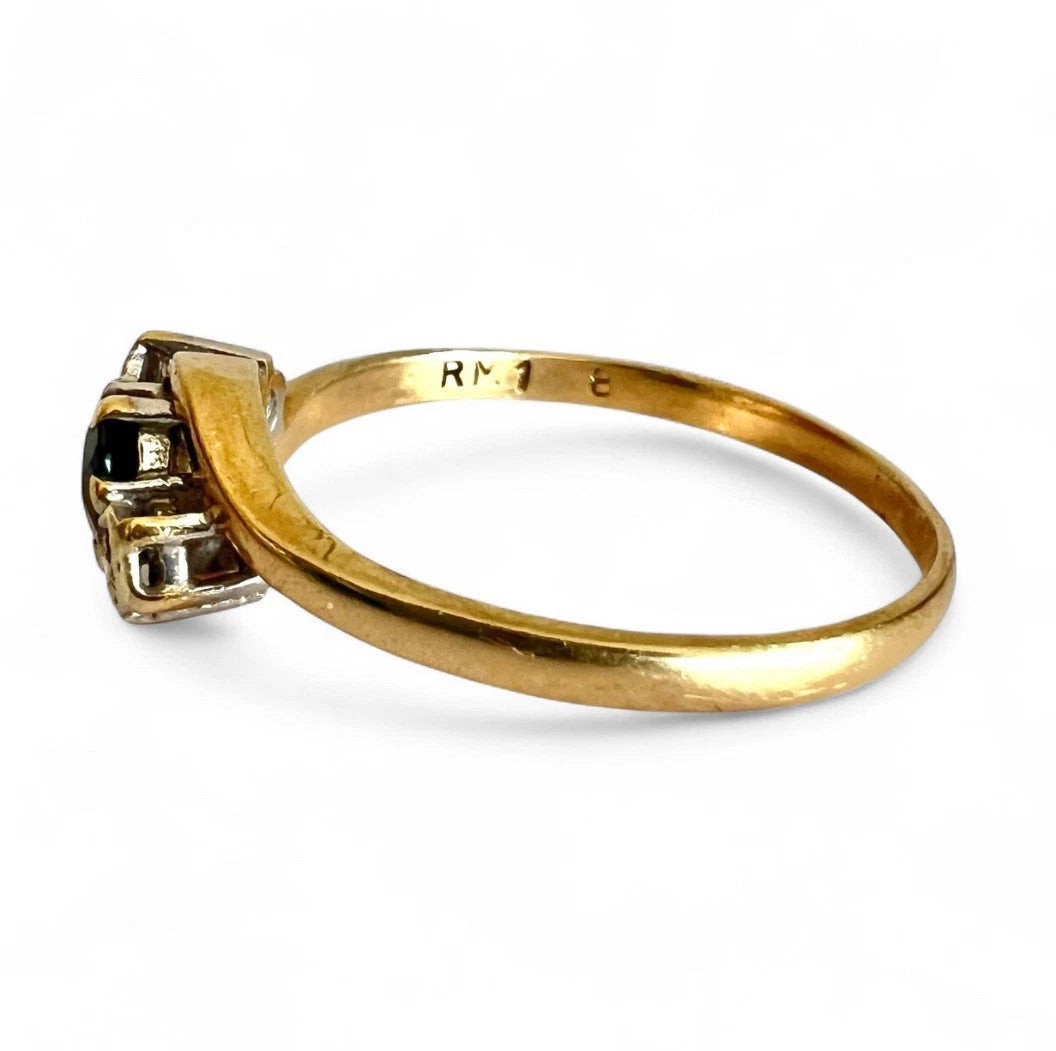 Gold ring with a sapphire and diamond on a white background