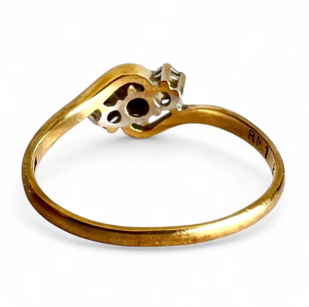 Gold ring with a sapphire and diamond on a white background