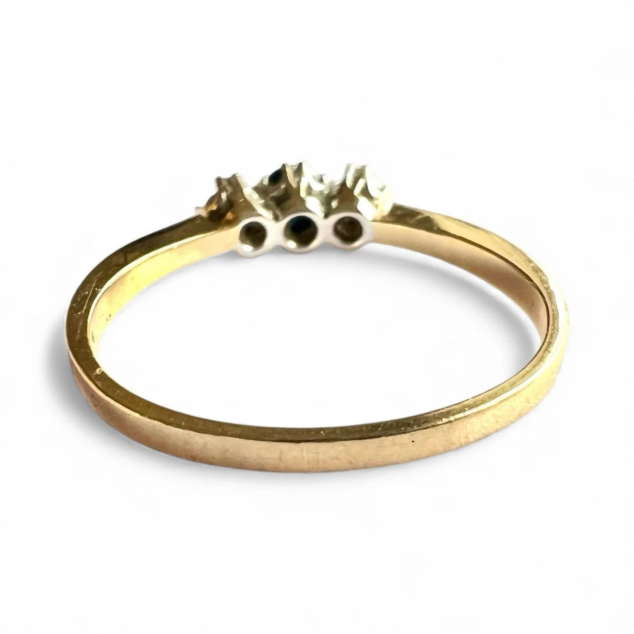 Gold ring with three small stones on a white background