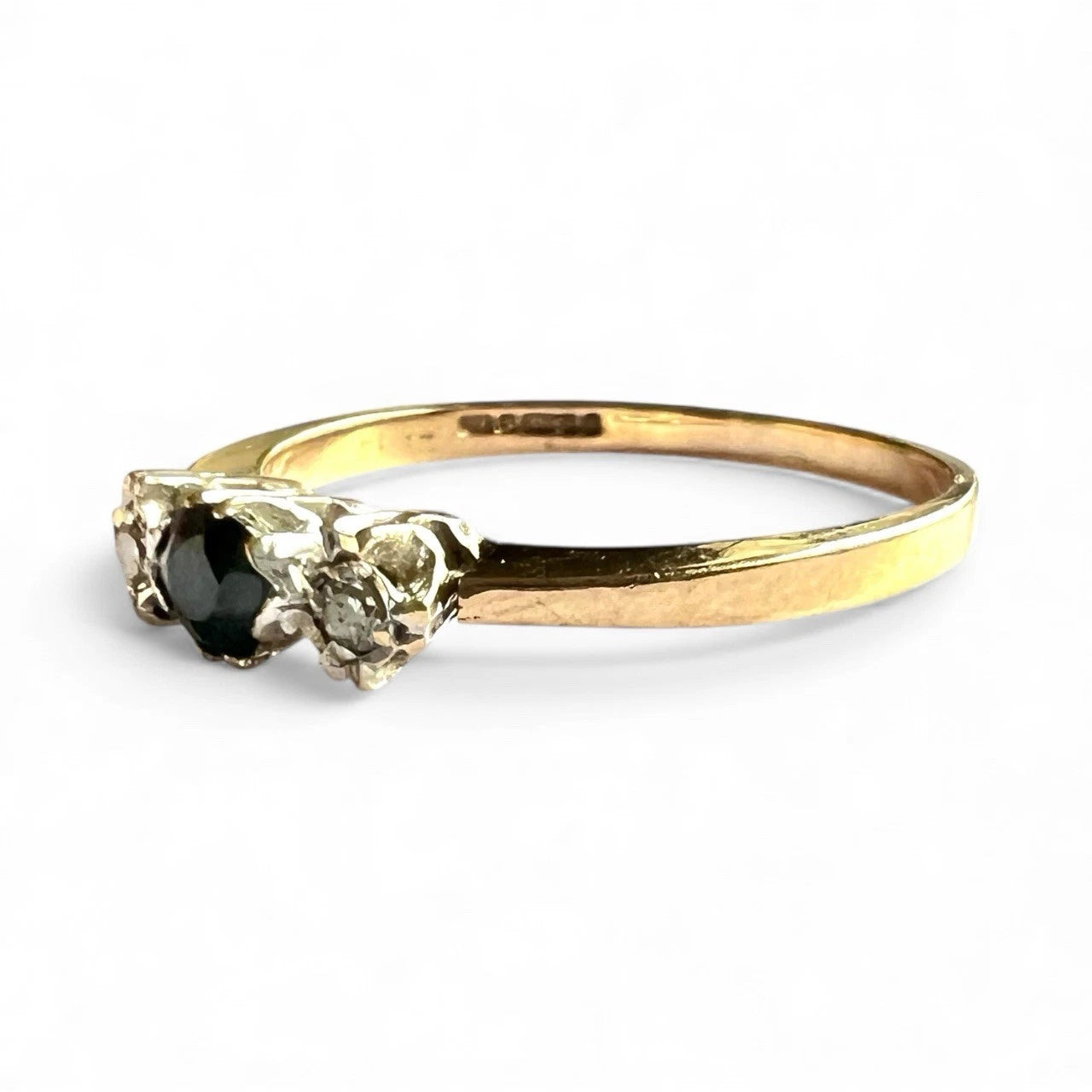 Gold ring with sapphire and diamonds on a white background