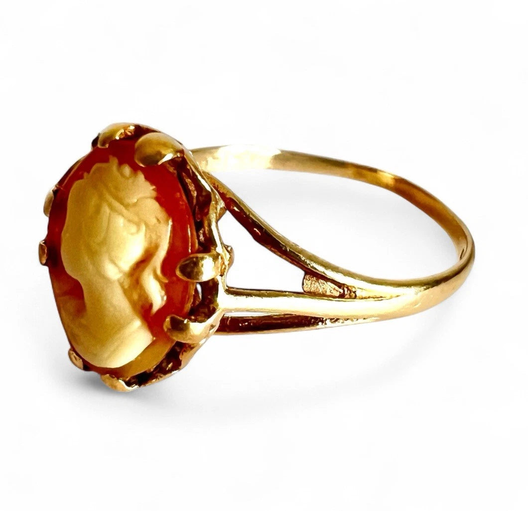 Gold cameo ring with lady profile on a white background