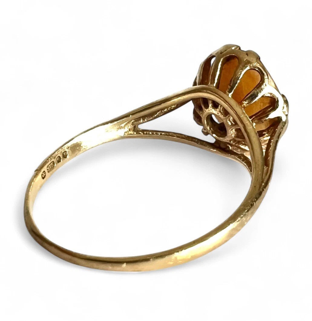 Gold ring with a decorative design on a white background