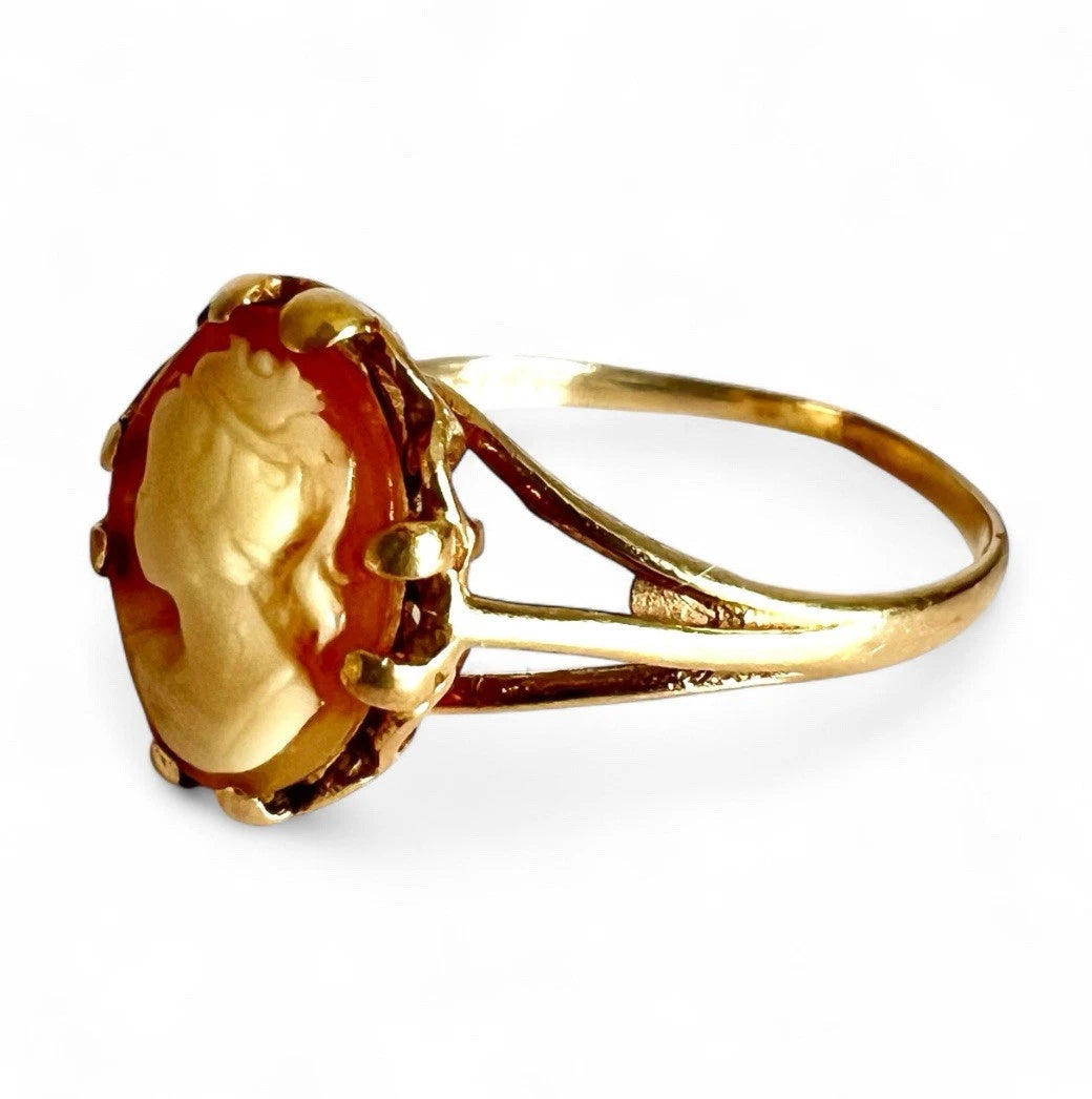 Gold cameo ring on a white background, close up side view 