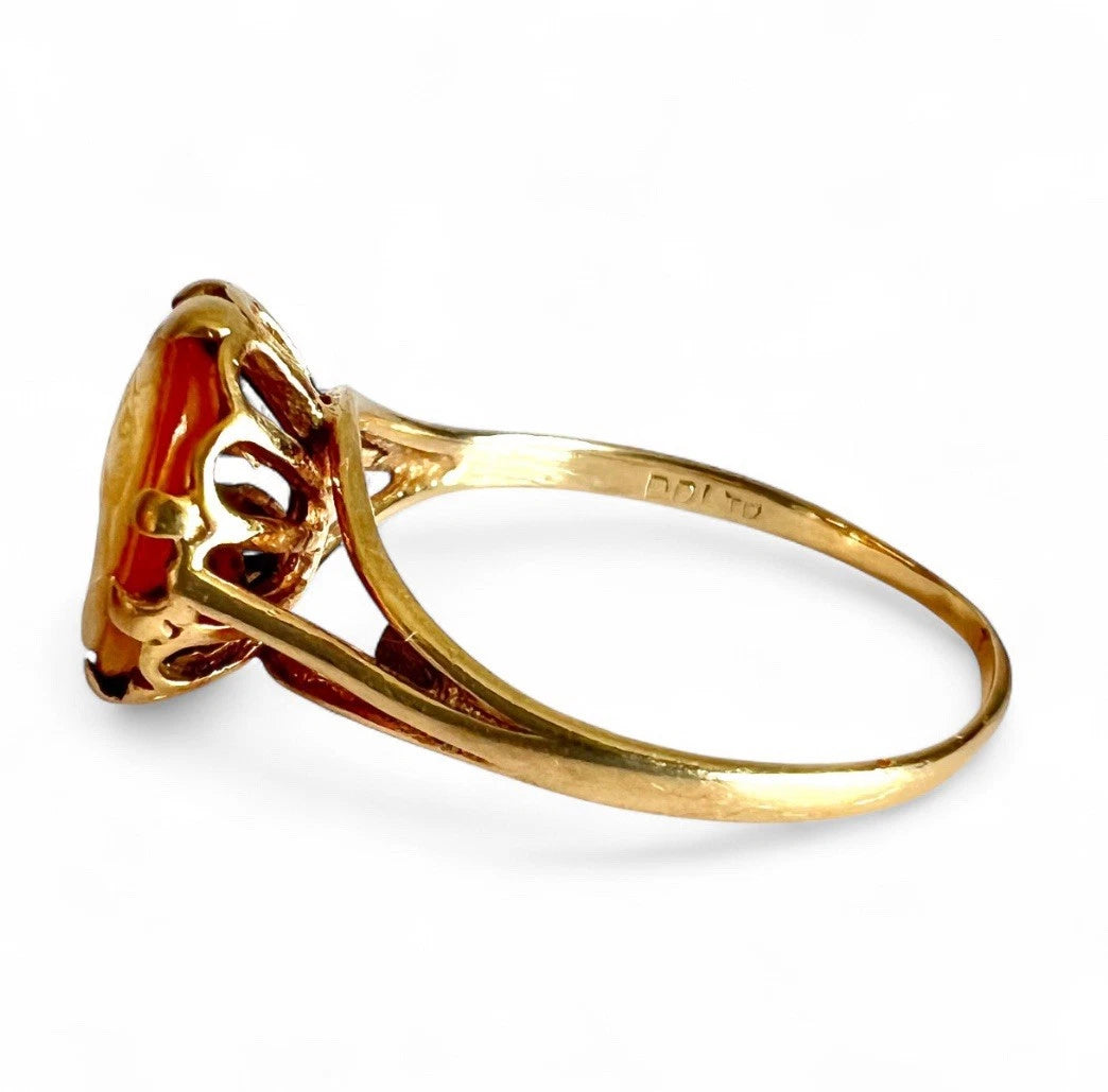 Gold ring with cameo design on a white background