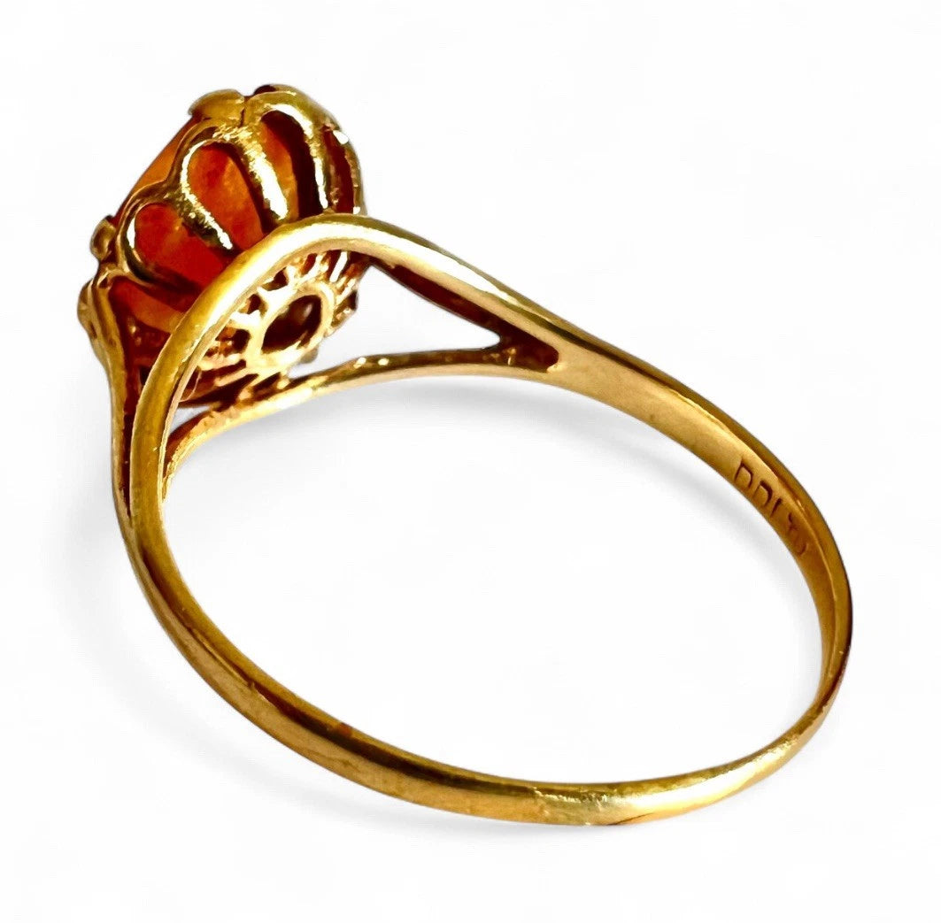 Gold ring with intricate design on a white background