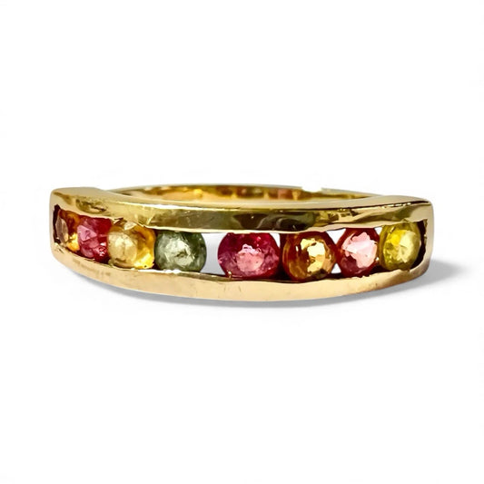 Gold ring with multicoloured spinel gemstones on a white background