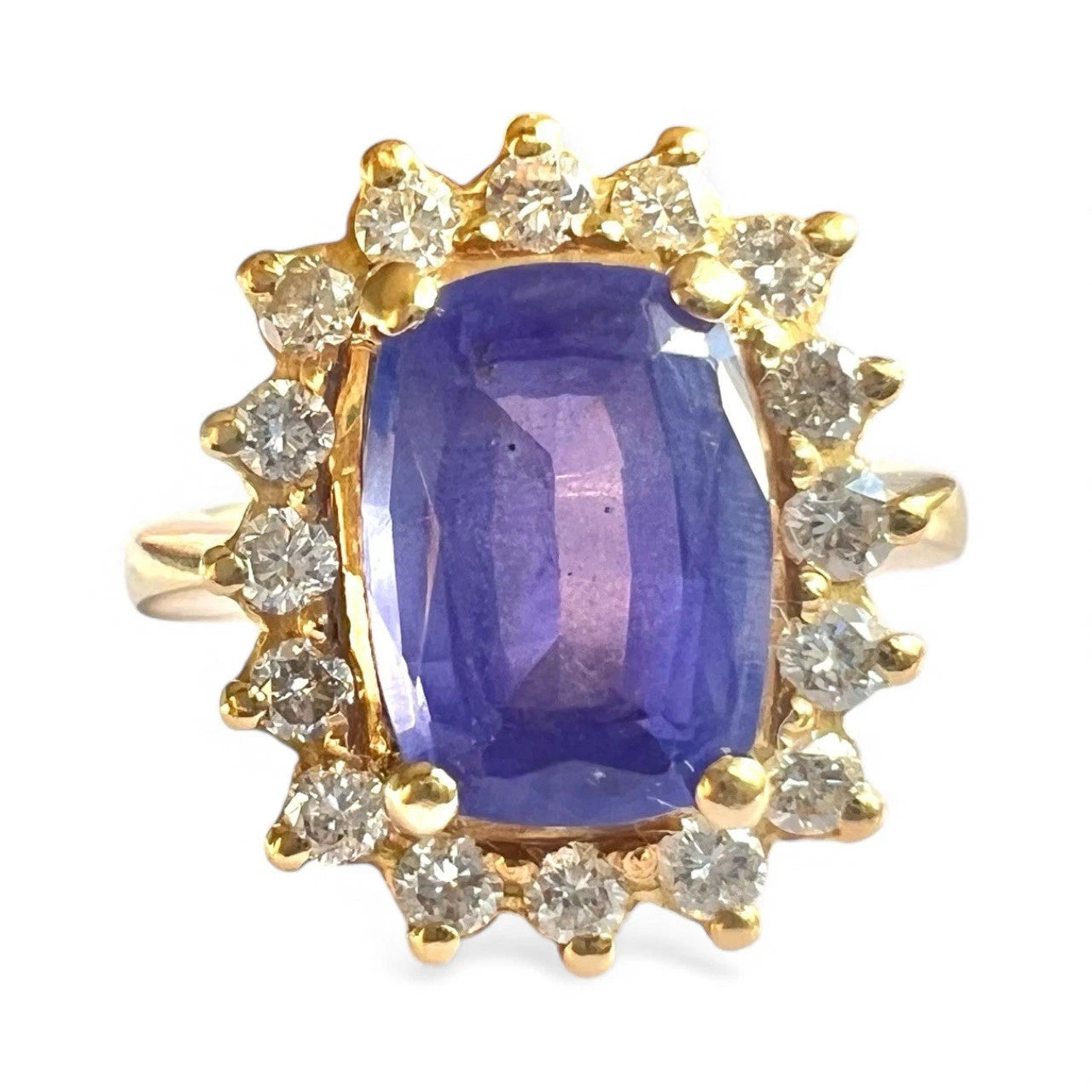 Vintage Gold ring with a blue tanzanite gemstone and diamond halo on a white background, close-up front view of setting 