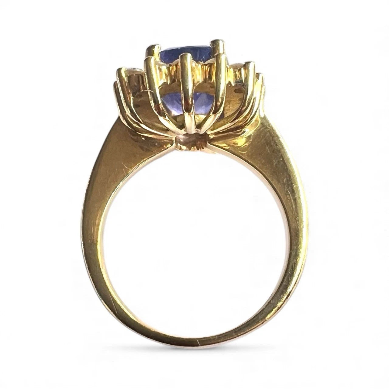 Gold ring with a blue tanzanite gemstone on a white background, close up top down view 