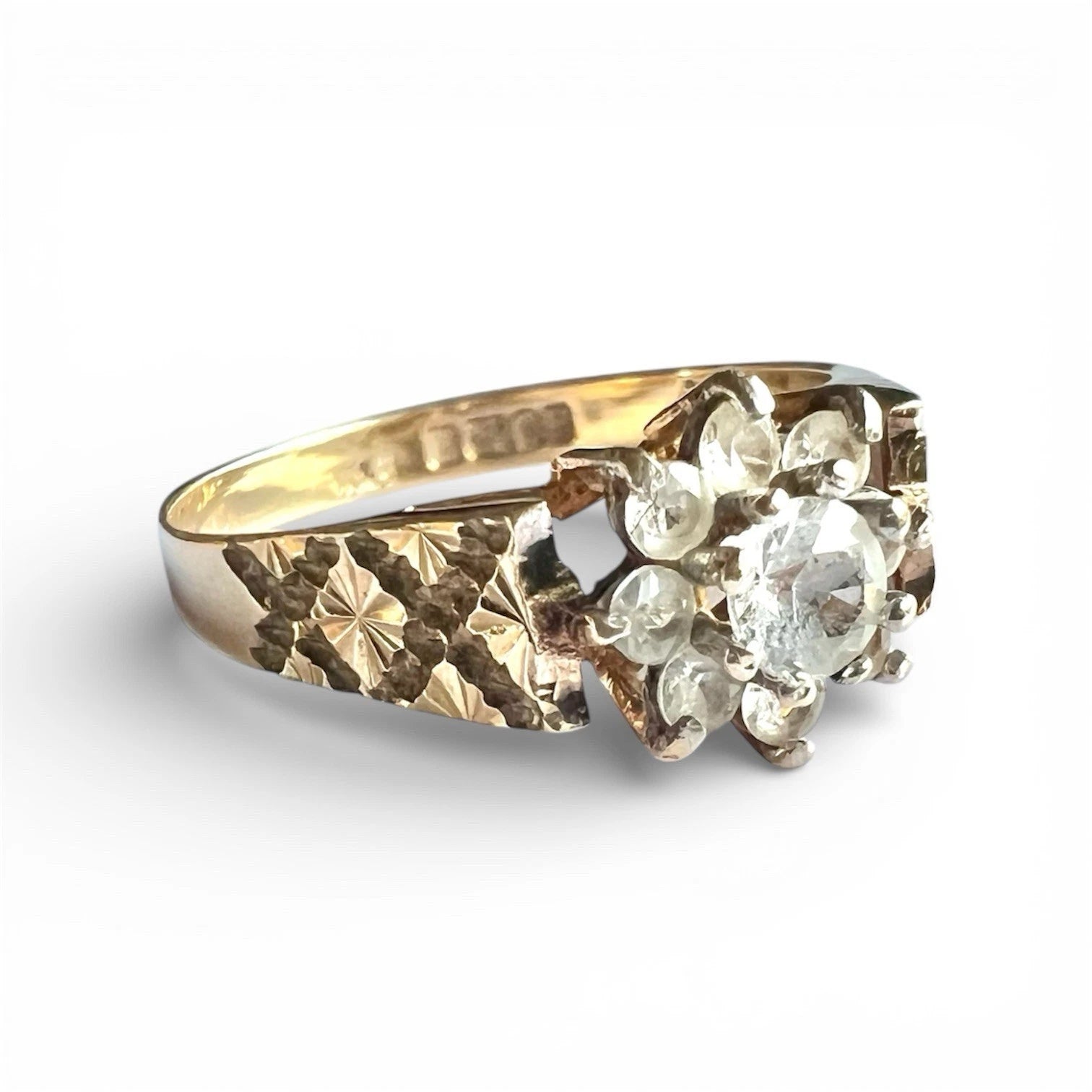 Gold ring with ice blue topaz flower cluster on a white background, close up side view 