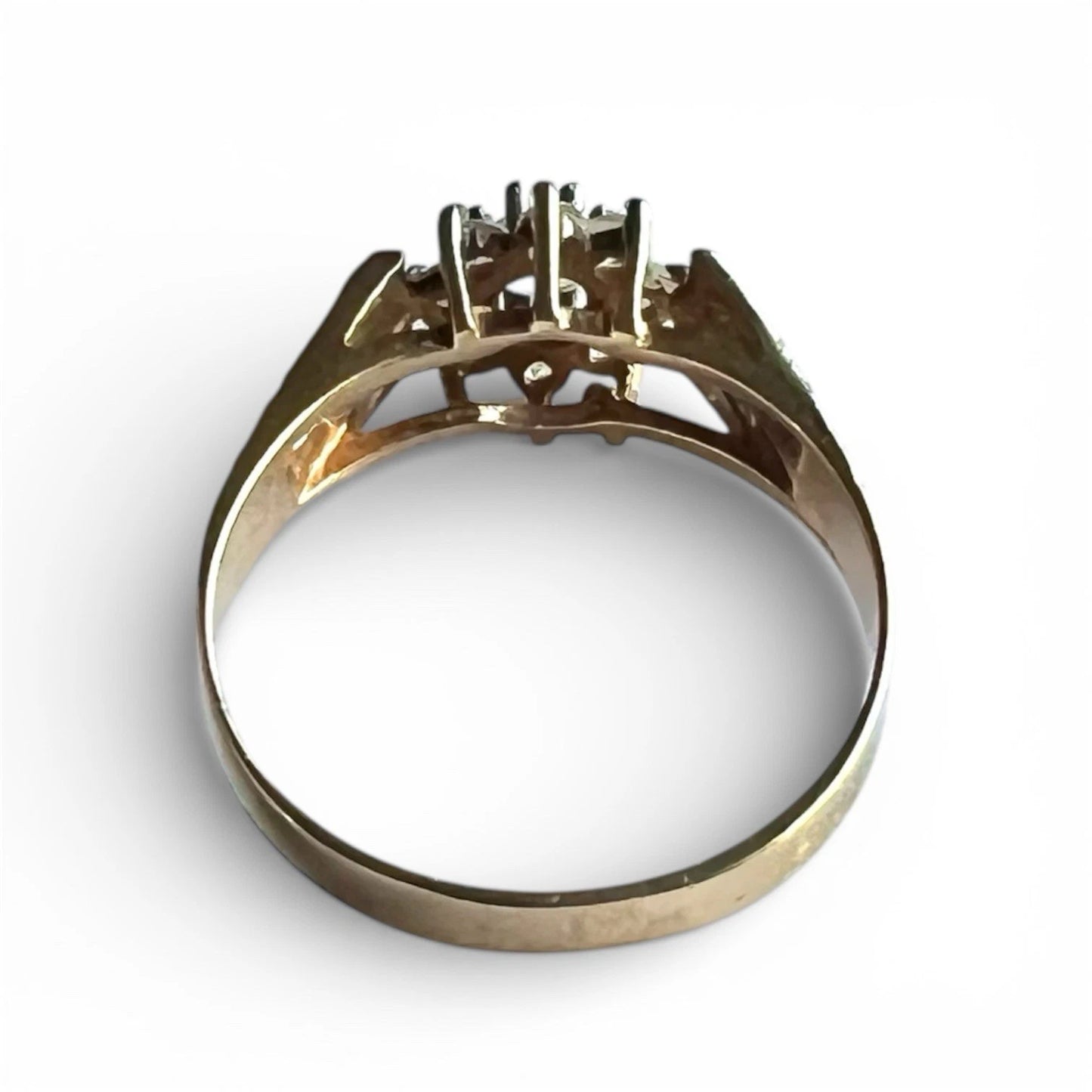 Gold ring with a ice blue topaz on a white background, close up rear view of setting and gold band 