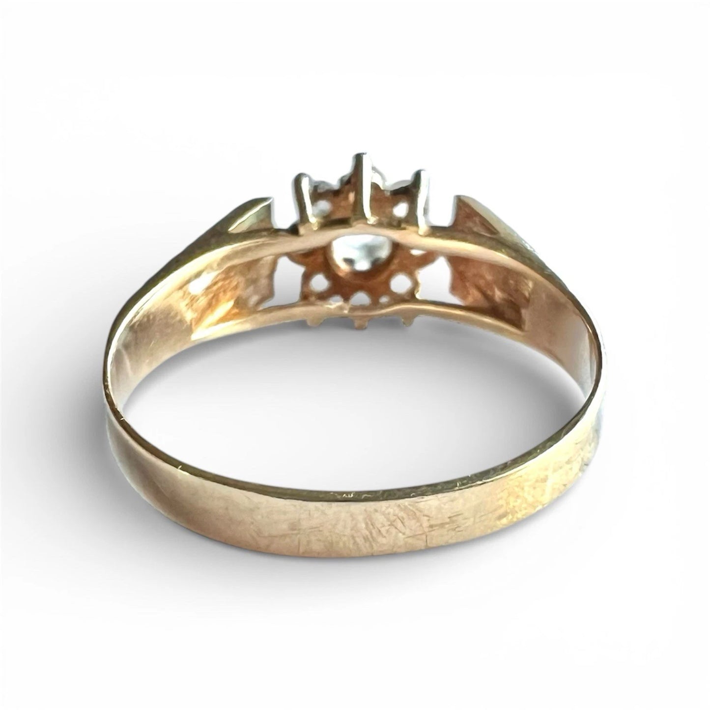 Vintage Gold ring with a ice blue topaz flower cluster on a white background, close up rear view 