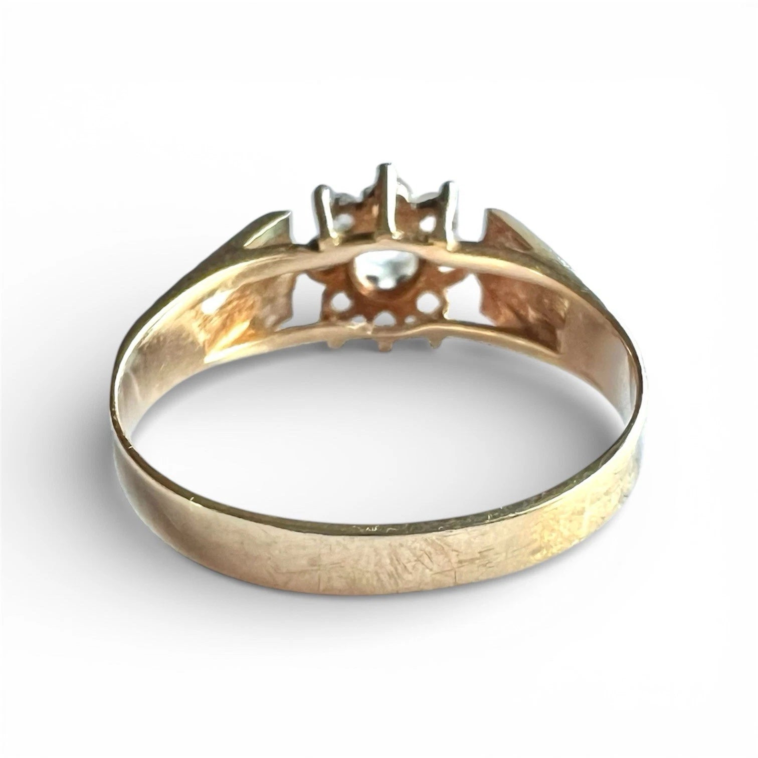 Vintage Gold ring with a ice blue topaz flower cluster on a white background, close up rear view 