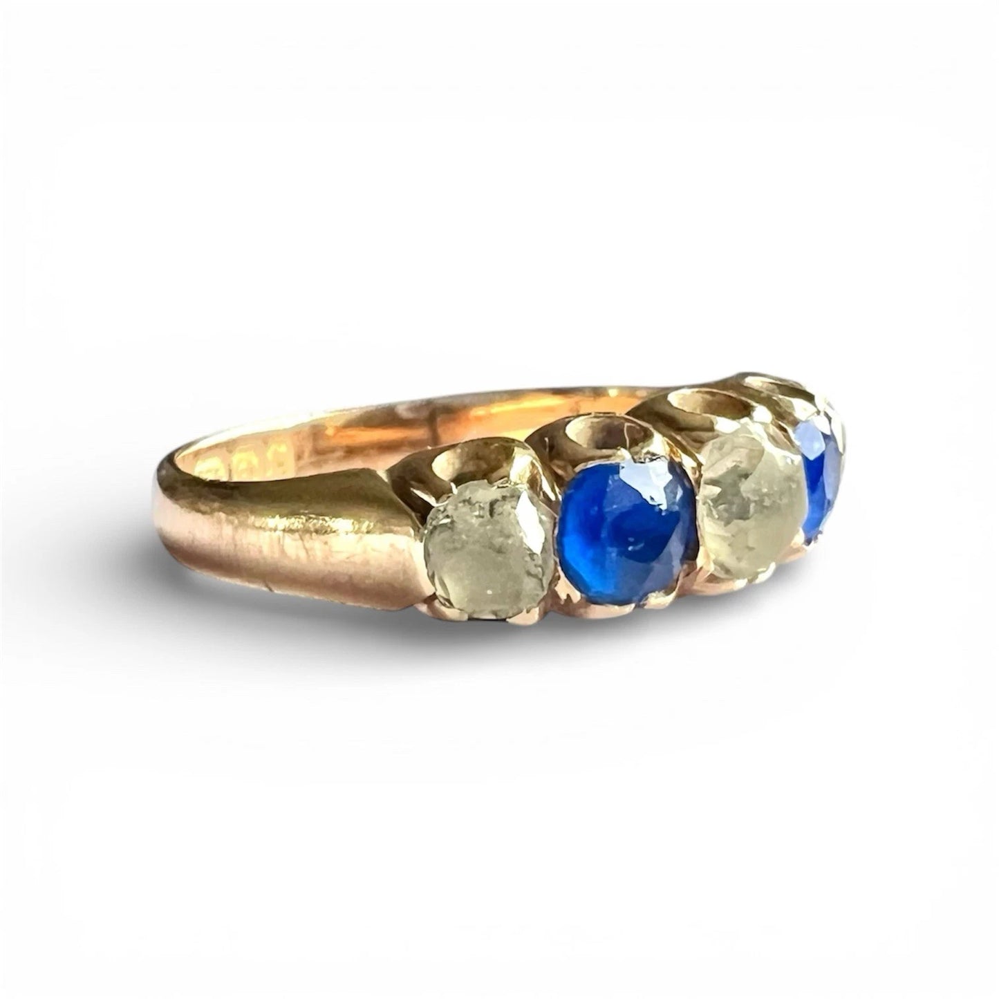 Victorian Gold ring with a blue and clear gemstone on a white background