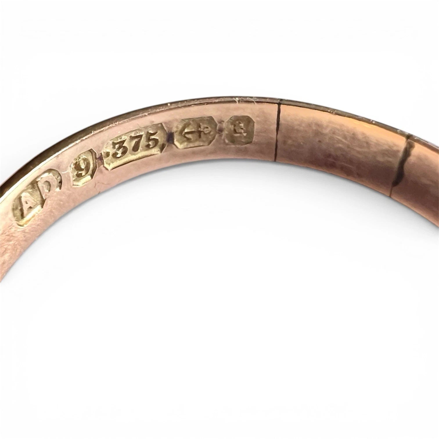 Close-up of an antique gold ring with visible hallmarks on a white background