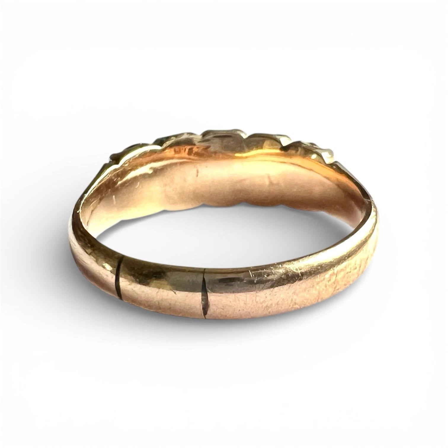 Gold ring with with blue and clear gemstones design on a white background, close up rear view of setting and gold band 