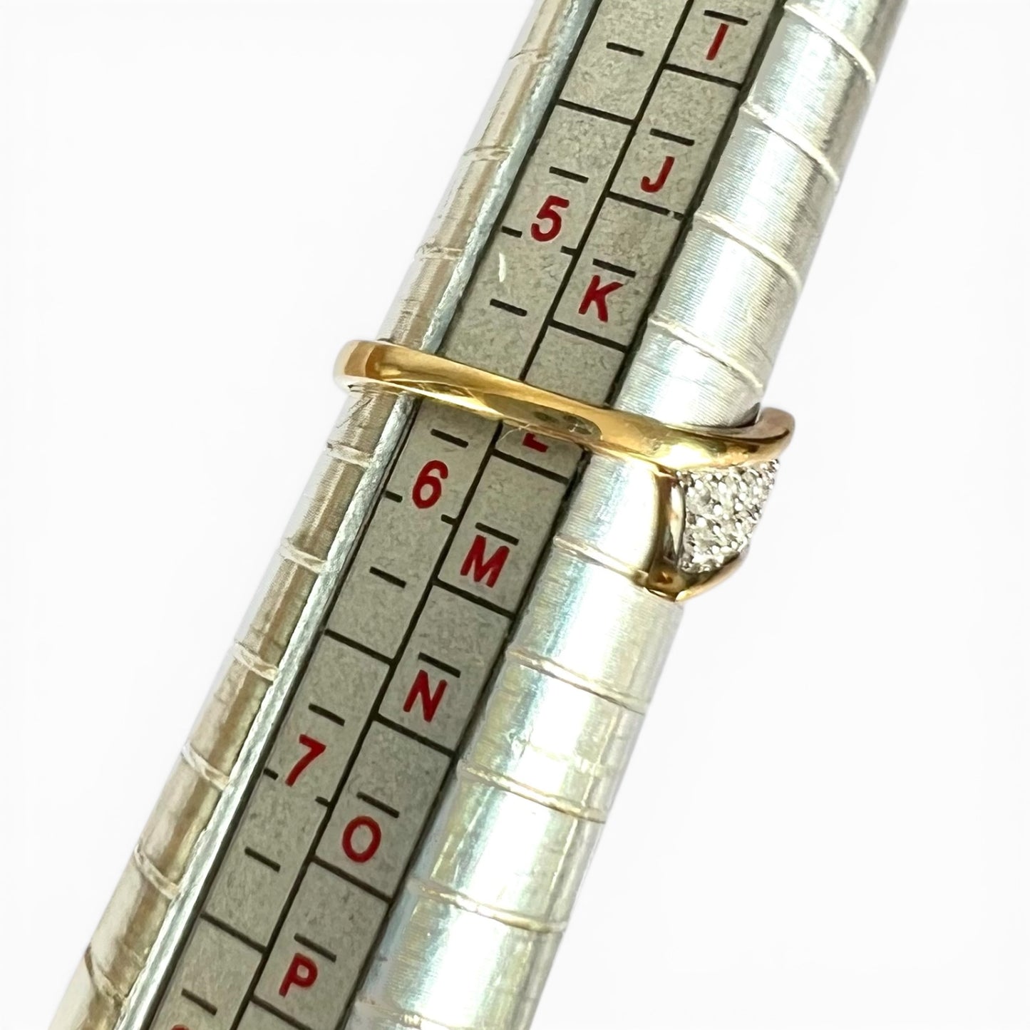 Metallic ring sizer gauge displaying ring size on a white background