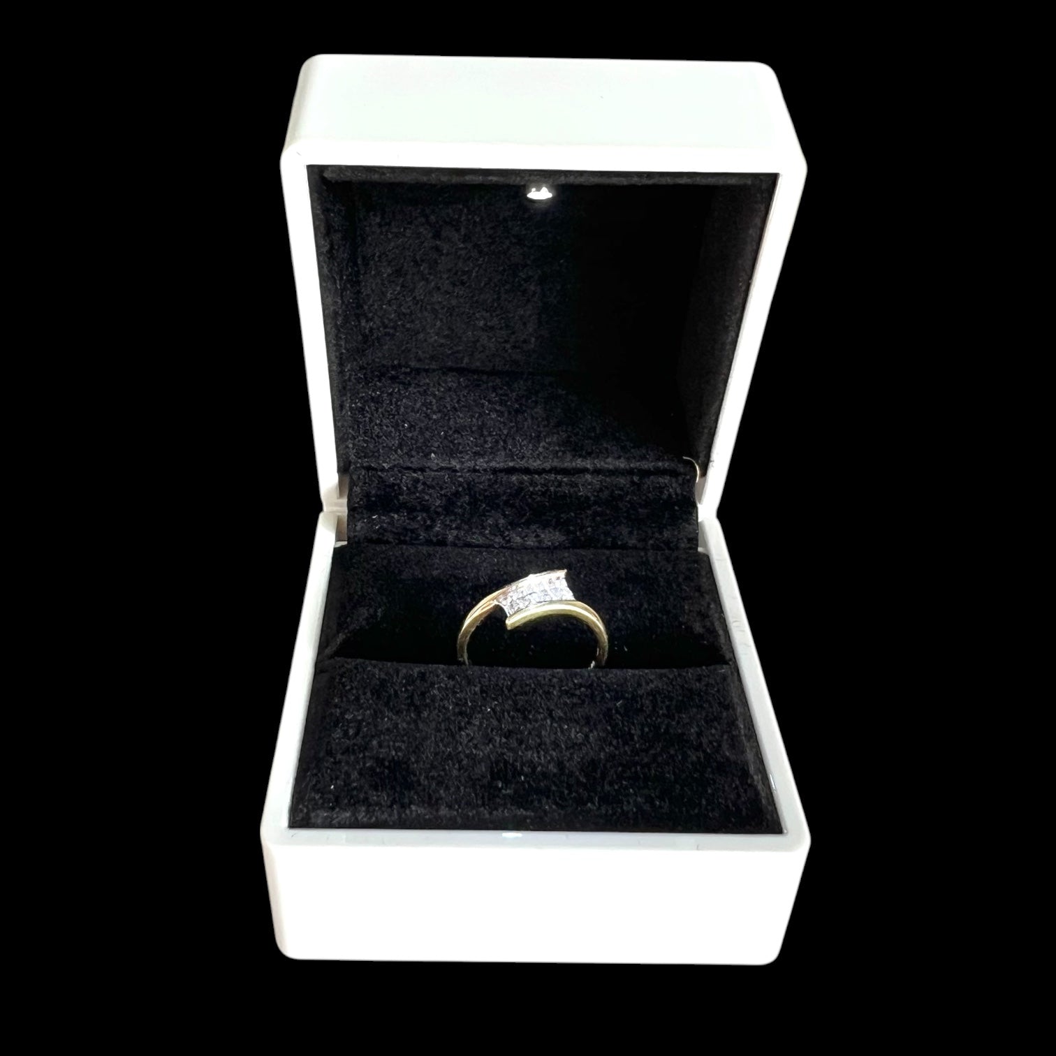 Gold diamond ring in a white jewellery box with a black interior